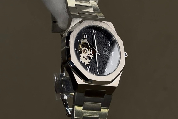 Silver watch with a detailed face on a dark background